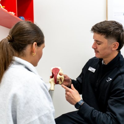 Podiatrist explaining foot mobilisation with a joint model in Toowoomba